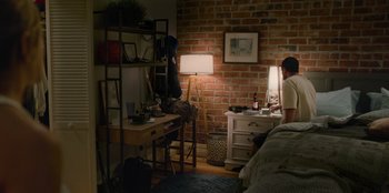 Movie still from “Murder Mystery 2” (2023), directed by Jeremy Garelick – A person sitting at a desk in front of a computer in a room; Wide shot, High angle