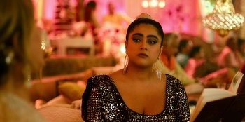 Movie still from “Murder Mystery 2” (2023), directed by Jeremy Garelick – A woman in a black and white dress and a white hat; Close Up shot, Over the shoulder angle