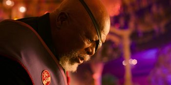 Movie still from “Murder Mystery 2” (2023), directed by Jeremy Garelick – An older man with a beard and glasses looking to his left; Close Up shot, Low angle