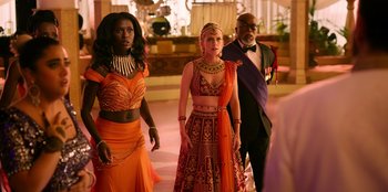 Movie still from “Murder Mystery 2” (2023), directed by Jeremy Garelick – A group of people standing next to each other in a room; Wide shot, Over the shoulder angle