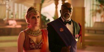 Movie still from “Murder Mystery 2” (2023), directed by Jeremy Garelick – A woman and a man dressed up in costumes; Medium shot, Over the shoulder angle