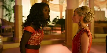 Movie still from “Murder Mystery 2” (2023), directed by Jeremy Garelick – Two women are standing in a room and one of them is talking to another woman; Medium shot, Over the shoulder angle