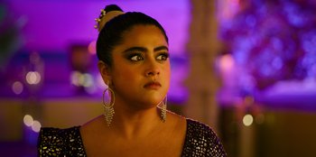 Movie still from “Murder Mystery 2” (2023), directed by Jeremy Garelick – A person wearing a dress; Close Up shot, Over the shoulder angle