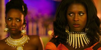 Movie still from “Murder Mystery 2” (2023), directed by Jeremy Garelick – A woman in a yellow dress and a woman in a black dress; Close Up shot, Over the shoulder angle
