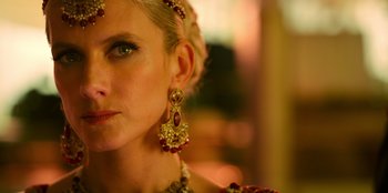Movie still from “Murder Mystery 2” (2023), directed by Jeremy Garelick – A woman wearing a necklace and a crown; Close Up shot, Over the shoulder angle
