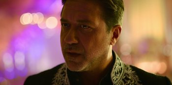 Movie still from “Murder Mystery 2” (2023), directed by Jeremy Garelick – A person wearing a black and white shirt; Close Up shot, Over the shoulder angle