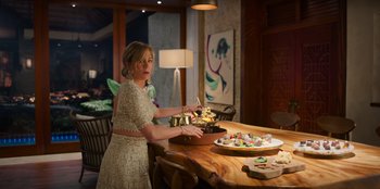 Movie still from “Murder Mystery 2” (2023), directed by Jeremy Garelick – A woman standing at a table with a cake; Medium shot, High angle
