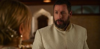 Movie still from “Murder Mystery 2” (2023), directed by Jeremy Garelick – A man with a beard wearing a white jacket; Close Up shot, Over the shoulder angle