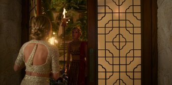 Movie still from “Murder Mystery 2” (2023), directed by Jeremy Garelick – A woman standing in front of a mirror holding a lit candle; Medium shot, Over the shoulder angle