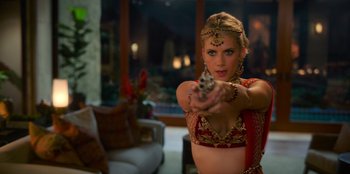 Movie still from “Murder Mystery 2” (2023), directed by Jeremy Garelick – A beautiful woman holding a gun in her hand; Medium shot, Over the shoulder angle