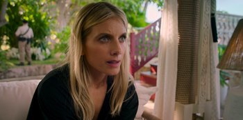 Movie still from “Murder Mystery 2” (2023), directed by Jeremy Garelick – A woman sitting on a chair looking at the camera; Close Up shot, Low angle