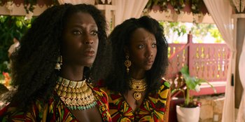 Movie still from “Murder Mystery 2” (2023), directed by Jeremy Garelick – Two black women wearing colorful clothing and jewelry; Close Up shot, Low angle