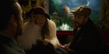 Movie still from “Murder Mystery 2” (2023), directed by Jeremy Garelick – A man and a woman sitting on a chair; Medium shot, Over the shoulder angle