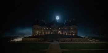 Movie still from “Murder Mystery 2” (2023), directed by Jeremy Garelick – A full moon rises over a large mansion; Extreme Wide shot, Low angle