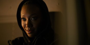 Movie still from “Murder Mystery 2” (2023), directed by Jeremy Garelick – A person wearing a hooded sweatshirt; Close Up shot, Over the shoulder angle