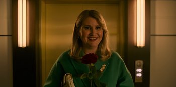 Movie still from “Murder Mystery 2” (2023), directed by Jeremy Garelick – A woman holding a red rose in her hand; Close Up shot, High angle
