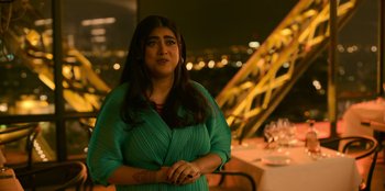 Movie still from “Murder Mystery 2” (2023), directed by Jeremy Garelick – A woman standing in front of a table with wine glasses on it; Medium shot, Over the shoulder angle