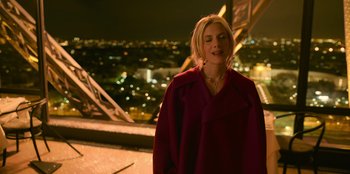 Movie still from “Murder Mystery 2” (2023), directed by Jeremy Garelick – A woman standing on top of a building at night; Medium shot, High angle