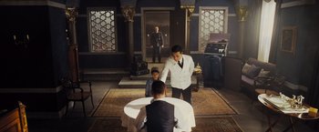 Movie still from “Murder on the Orient Express” (2017), directed by Kenneth Branagh – A man in a white jacket is standing in front of a man in a white jacket; Wide shot, Over the shoulder angle