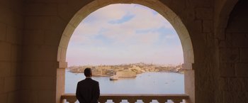 Movie still from “Murder on the Orient Express” (2017), directed by Kenneth Branagh – A man looking out over the water from a balcony; Wide shot, High angle