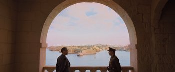 Movie still from “Murder on the Orient Express” (2017), directed by Kenneth Branagh – Two men are standing in front of the water; Wide shot, High angle