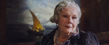 Movie still from “Murder on the Orient Express” (2017), directed by Kenneth Branagh – An older woman is looking into the distance; Close Up shot, Low angle