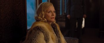 Movie still from “Murder on the Orient Express” (2017), directed by Kenneth Branagh – An older woman wearing a fur coat looking to her left; Close Up shot, Over the shoulder angle