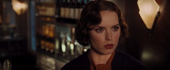 Movie still from “Murder on the Orient Express” (2017), directed by Kenneth Branagh – A beautiful woman with brown hair wearing a black jacket; Close Up shot, Over the shoulder angle