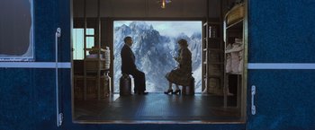 Movie still from “Murder on the Orient Express” (2017), directed by Kenneth Branagh – A man and a woman sitting in front of a window; Wide shot, Overhead angle