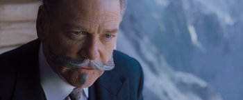 Movie still from “Murder on the Orient Express” (2017), directed by Kenneth Branagh – An older man with a mustache and a suit; Close Up shot, Low angle