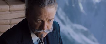 Movie still from “Murder on the Orient Express” (2017), directed by Kenneth Branagh – An older man wearing a suit and tie; Close Up shot, Low angle