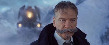 Movie still from “Murder on the Orient Express” (2017), directed by Kenneth Branagh – A person wearing a suit and tie; Close Up shot, Low angle