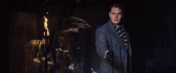 Movie still from “Murder on the Orient Express” (2017), directed by Kenneth Branagh – A man in a suit and tie holding a glove; Medium shot, Low angle