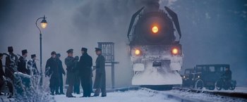 Movie still from “Murder on the Orient Express” (2017), directed by Kenneth Branagh – A group of men standing in front of a train; Extreme Wide shot, Low angle