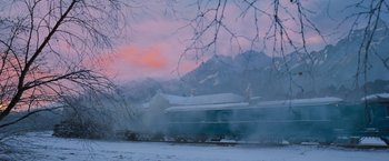 Movie still from “Murder on the Orient Express” (2017), directed by Kenneth Branagh – A train traveling down train tracks next to snow covered mountains; Extreme Wide shot, Low angle