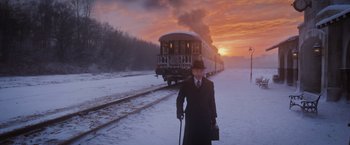 Movie still from “Murder on the Orient Express” (2017), directed by Kenneth Branagh – A man standing in front of a train on a train track; Wide shot, Low angle