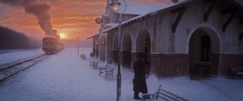 Movie still from “Murder on the Orient Express” (2017), directed by Kenneth Branagh – A person standing in front of a building on a snowy day; Extreme Wide shot, Low angle