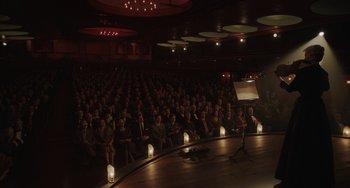 Movie still from “My Policeman” (2022), directed by Michael Grandage – An audience is sitting in front of a microphone; Extreme Wide shot, High angle
