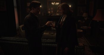 Movie still from “My Policeman” (2022), directed by Michael Grandage – A man and a woman holding a glass of wine; Medium shot, Over the shoulder angle