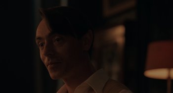 Movie still from “My Policeman” (2022), directed by Michael Grandage – A person wearing a dress shirt and tie; Close Up shot, Over the shoulder angle