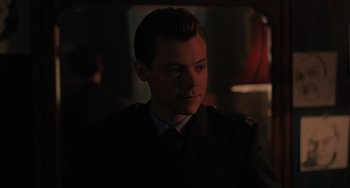 Movie still from “My Policeman” (2022), directed by Michael Grandage – A young man in a military uniform looking at the camera; Close Up shot, Over the shoulder angle