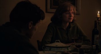 Movie still from “My Policeman” (2022), directed by Michael Grandage – A woman sitting at a table in front of another woman; Medium shot, Over the shoulder angle