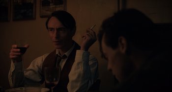 Movie still from “My Policeman” (2022), directed by Michael Grandage – A man sitting in front of another man holding a cigarette; Close Up shot, Over the shoulder angle