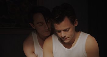 Movie still from “My Policeman” (2022), directed by Michael Grandage – Two men in white shirts embracing each other in the dark; Close Up shot, High angle