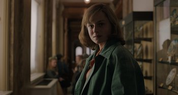 Movie still from “My Policeman” (2022), directed by Michael Grandage – A woman in a green jacket standing in a room; Close Up shot, Over the shoulder angle