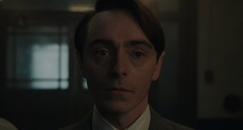 Movie still from “My Policeman” (2022), directed by Michael Grandage – A person wearing a suit and tie; Close Up shot, Low angle