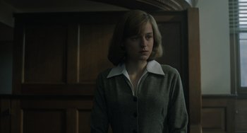 Movie still from “My Policeman” (2022), directed by Michael Grandage – A woman standing in front of a wooden door; Medium shot, Low angle