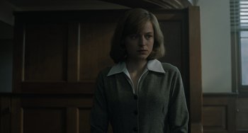 Movie still from “My Policeman” (2022), directed by Michael Grandage – A woman standing in front of a wooden door; Medium shot, Low angle