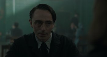 Movie still from “My Policeman” (2022), directed by Michael Grandage – A person wearing a suit and tie; Close Up shot, Over the shoulder angle