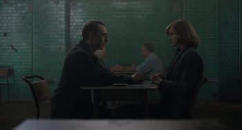 Movie still from “My Policeman” (2022), directed by Michael Grandage – A man and a woman sitting at a wooden table; Medium shot, Over the shoulder angle